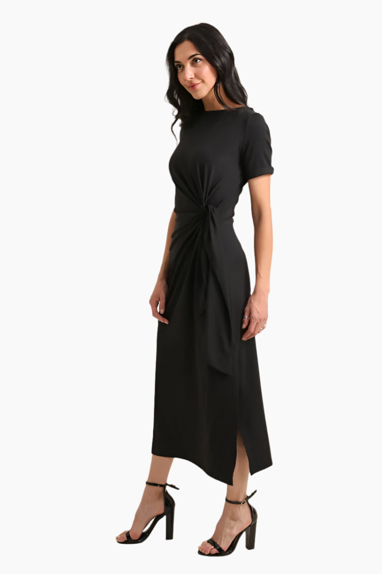 Woman wearing a black dress with a knot detail