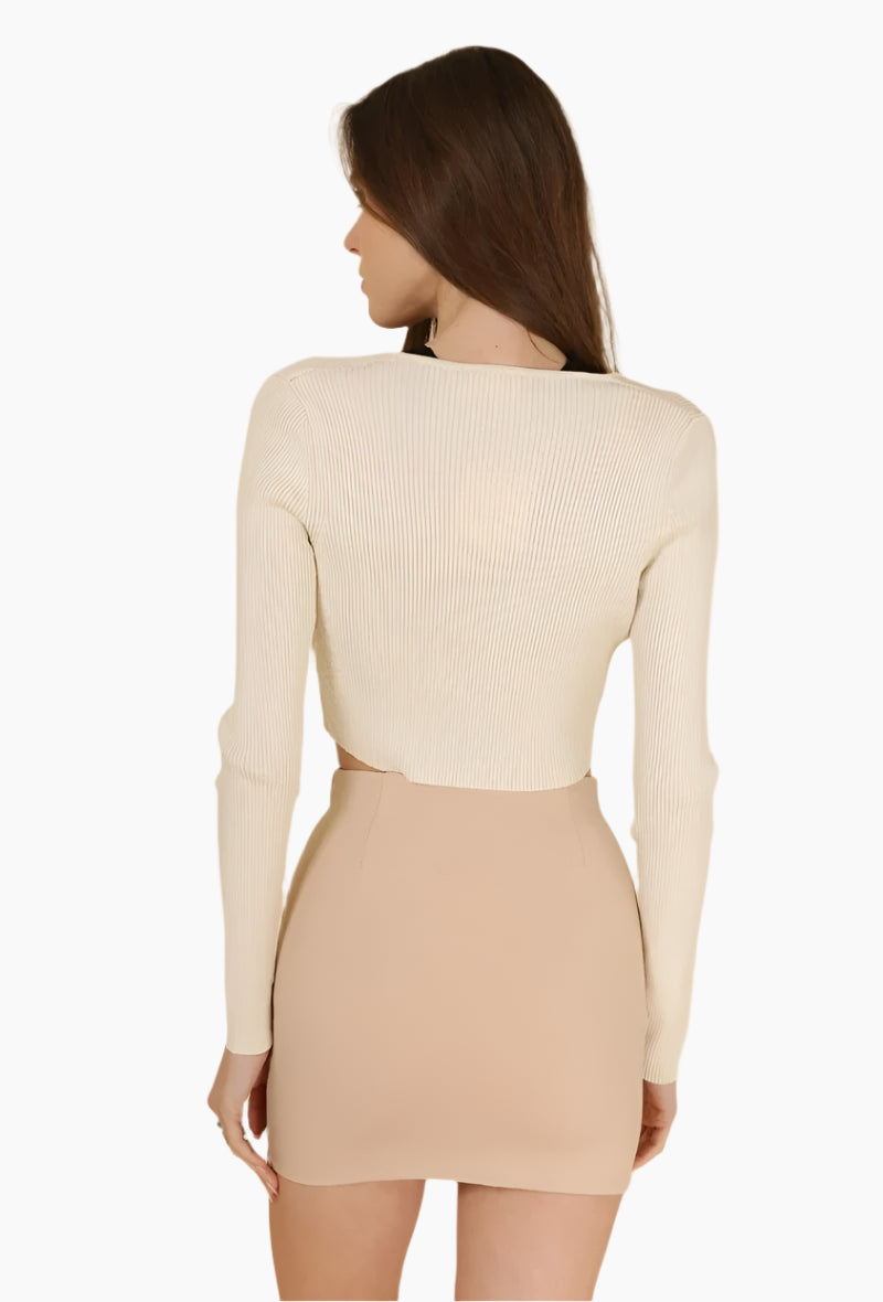 Woman wearing a beige long-sleeve top and skirt set