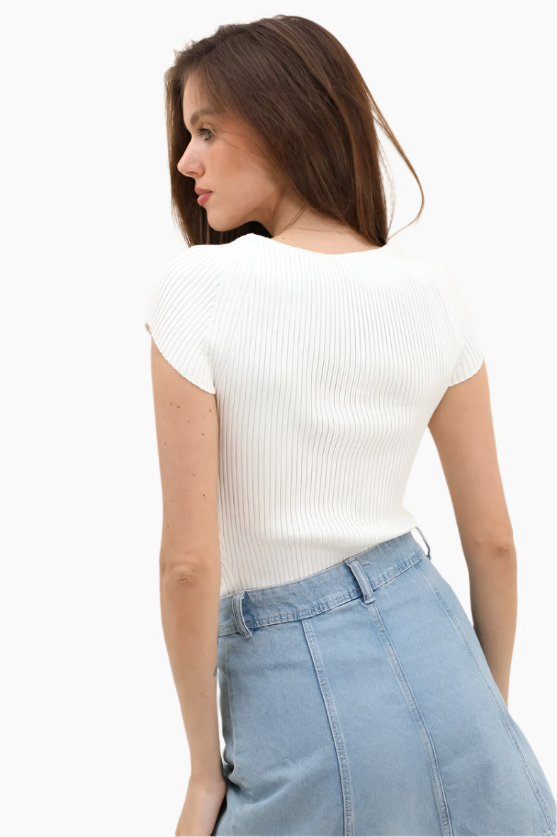 Woman wearing a white ribbed top and light blue jeans