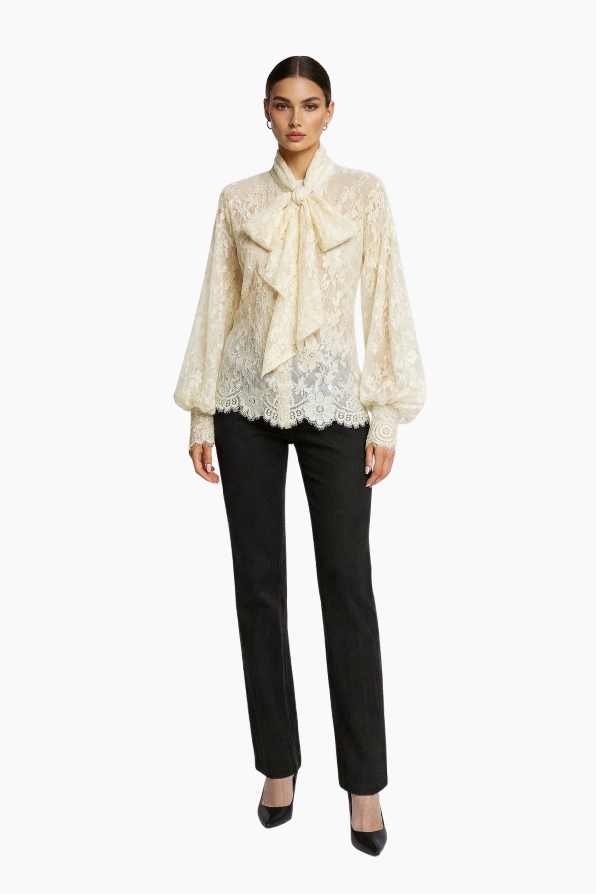 Woman wearing a cream lace blouse and black pants on a white background