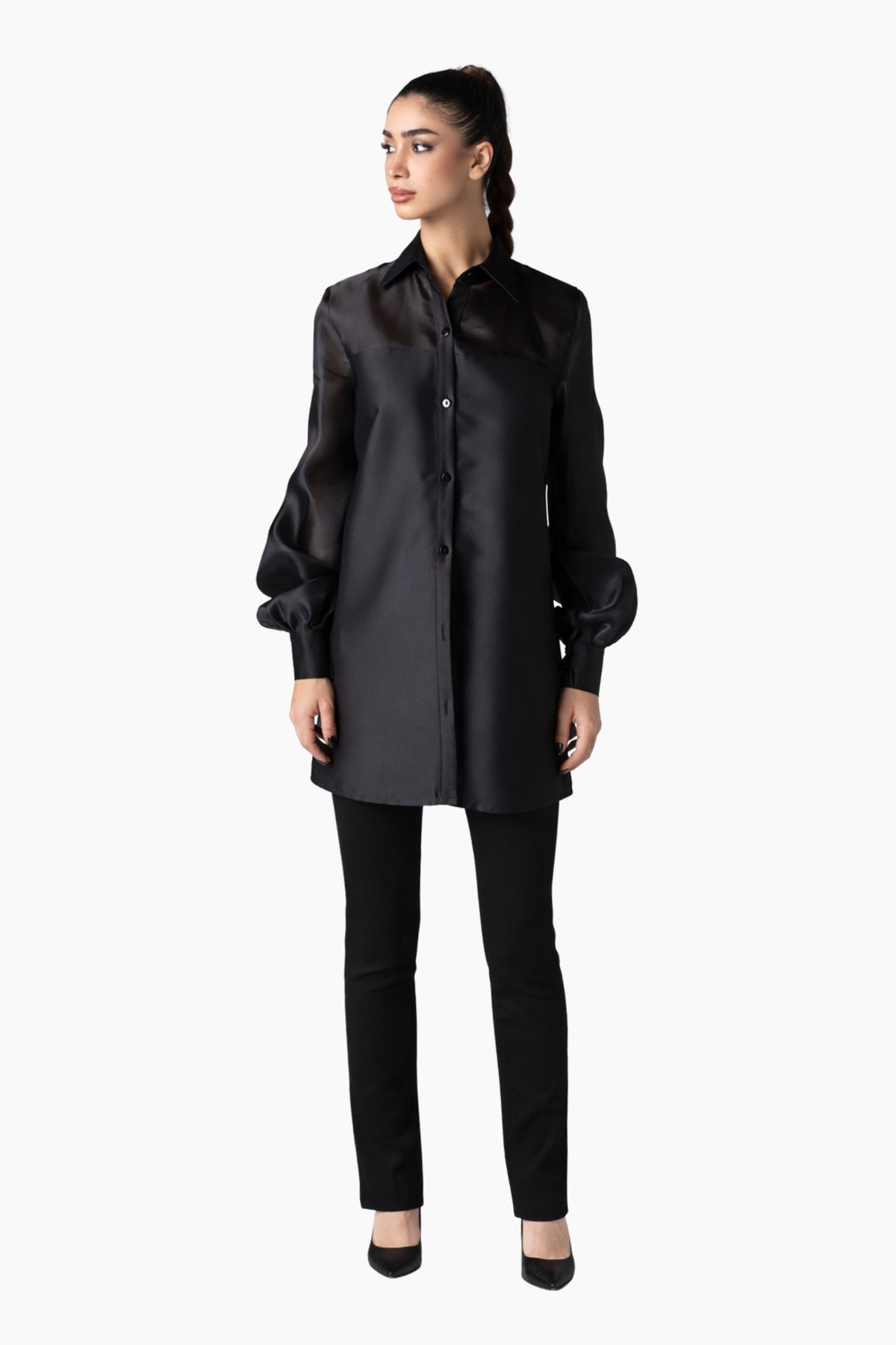 Woman wearing a black coat and pants on a white background
