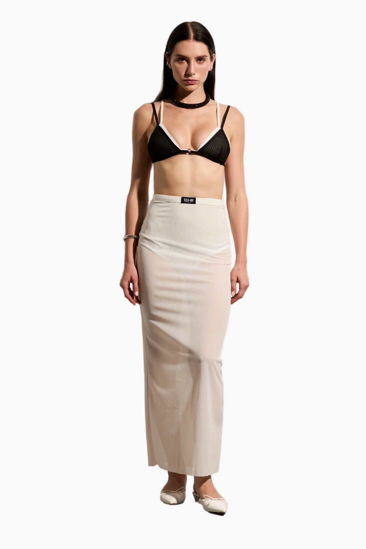 Woman wearing a black bra and beige skirt