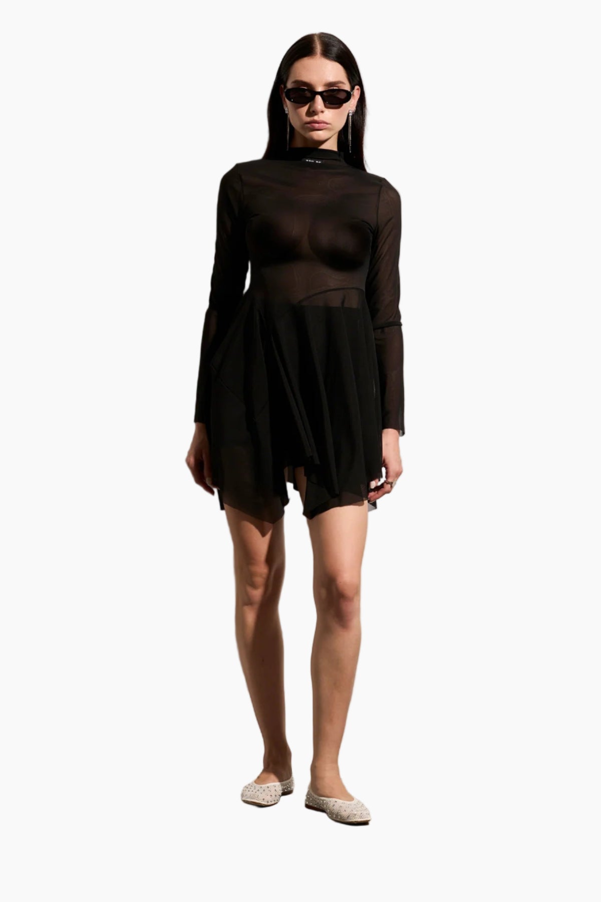 Woman wearing a black Turtleneck full mesh dress with an asymmetrical skirt cut.