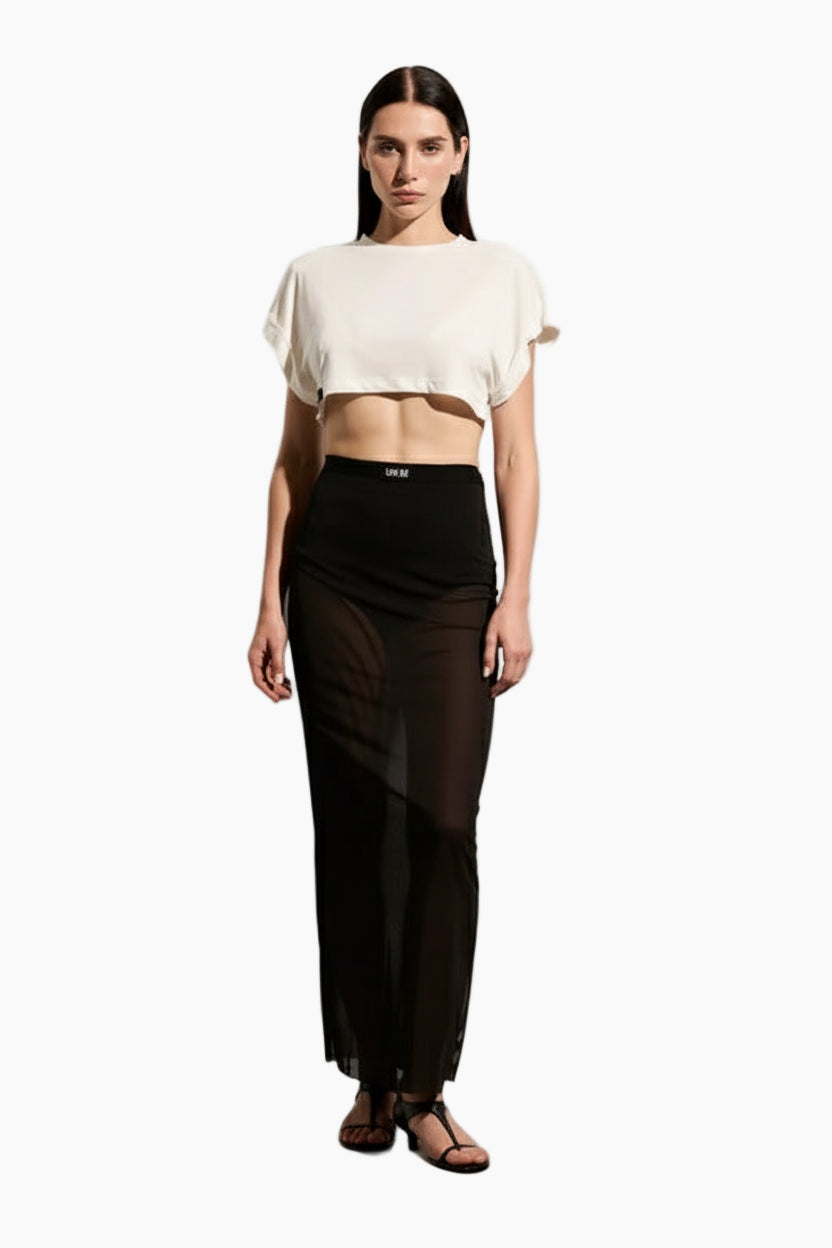 Woman wearing a beige crop top and Mesh long skirt