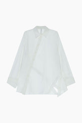  loose-fit shirt features an asymmetric back design highlighted by a distinctive diagonal button closure. A classic collar and long sleeves with cuffs frame a contemporary silhouette.