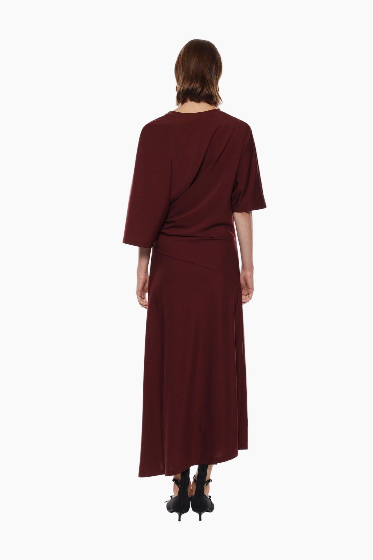 Woman wearing a burgundy dress with a draped design 