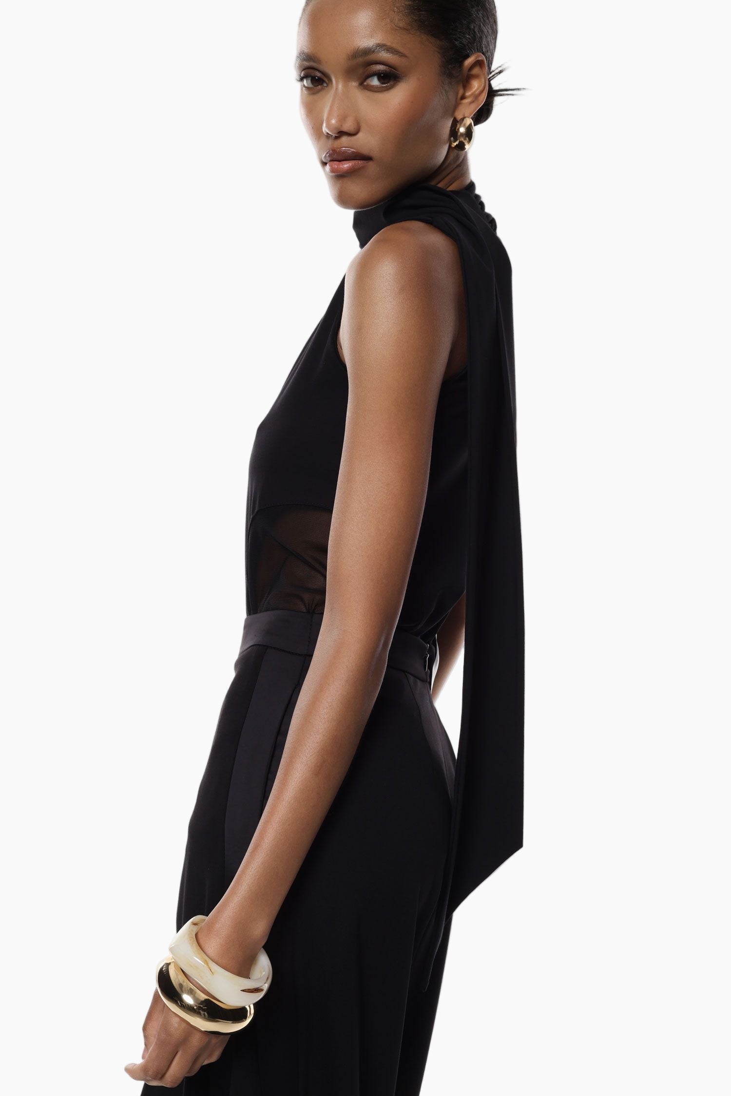 Woman wearing a black sleeveless bodysuit with sheer panels 