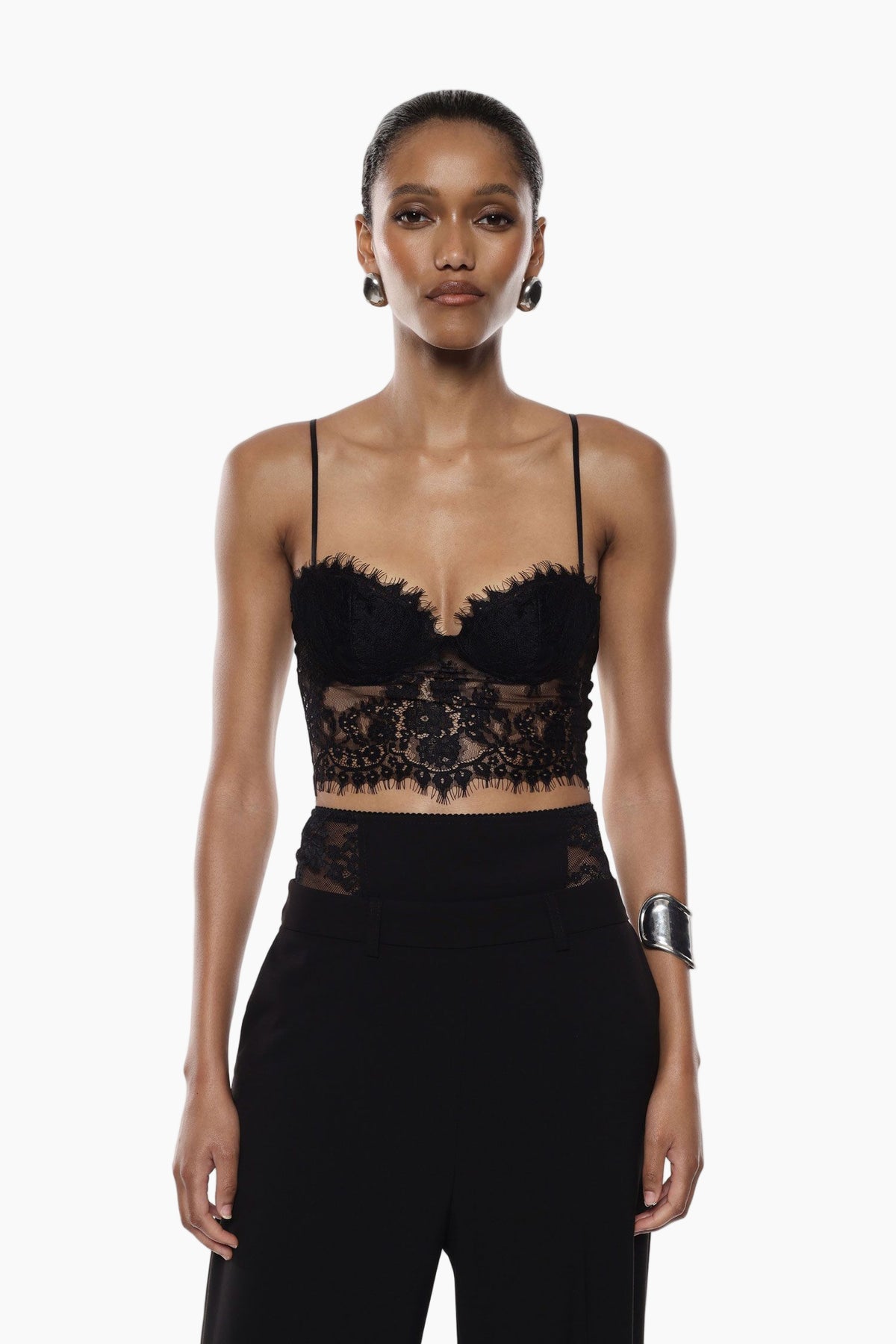 Model wearing a black lace top and high-waisted pants 