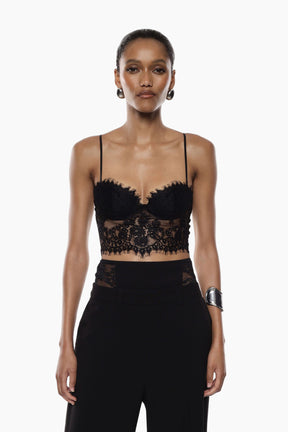 Model wearing a black lace top and high-waisted pants 