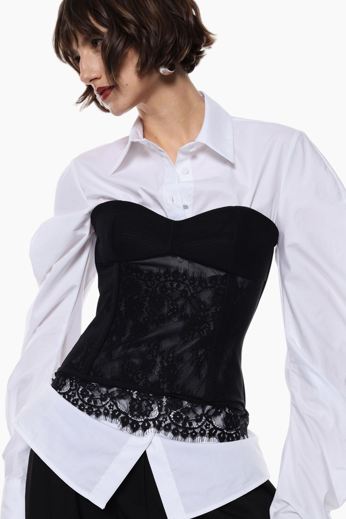 Woman wearing a black corset over a white shirt 