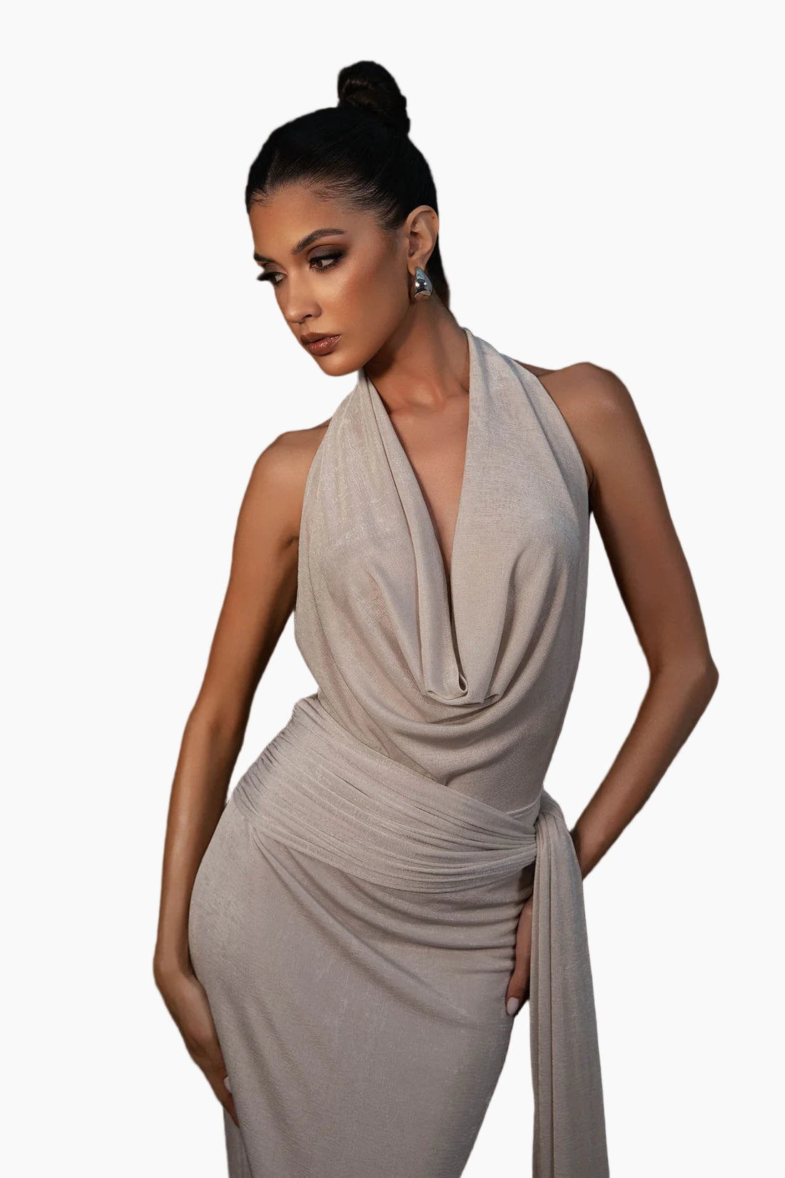 Woman wearing a light gray halter neck dress against a dark background