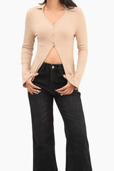 Person wearing a beige cardigan and black jeans 