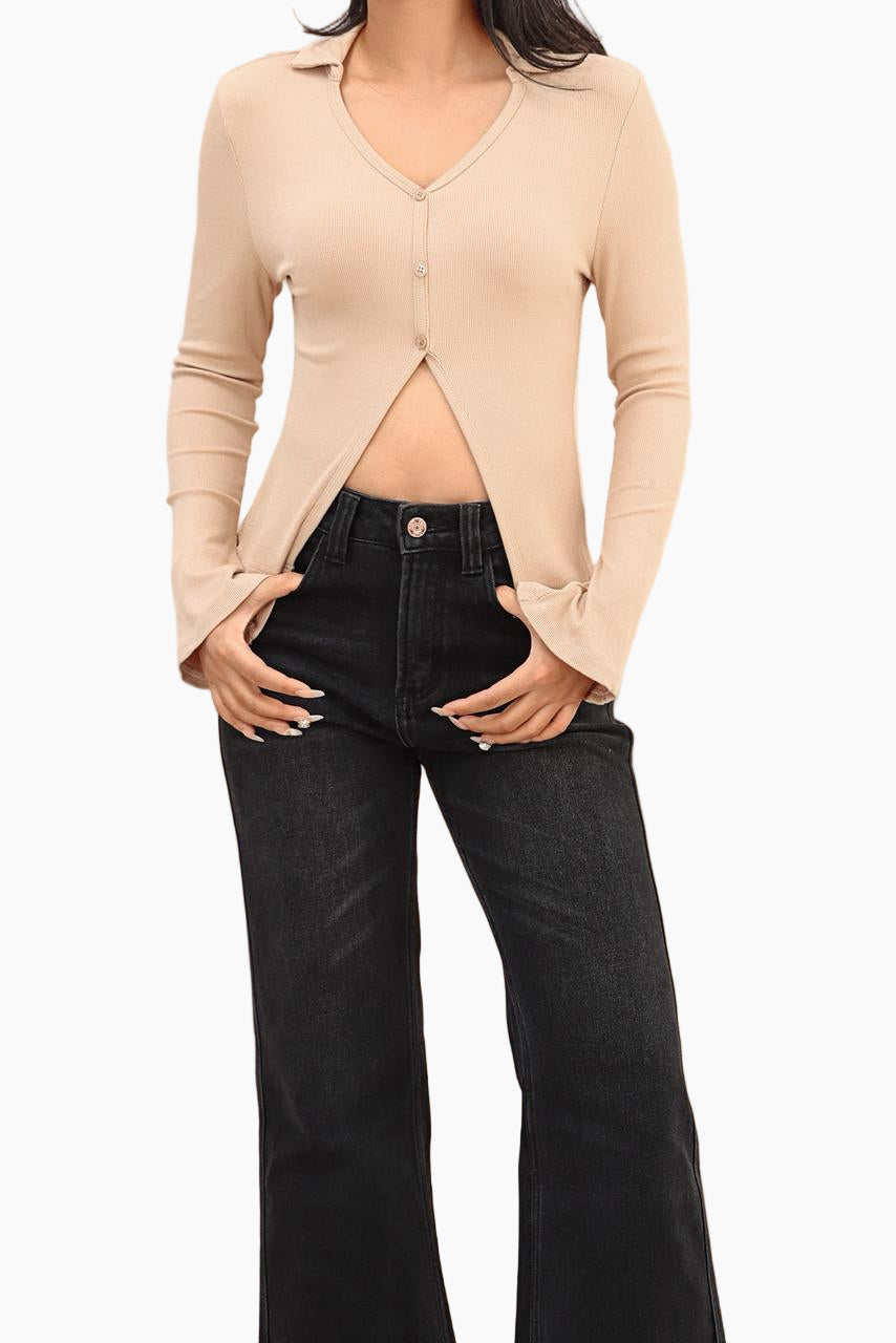Person wearing a beige cardigan and black jeans 