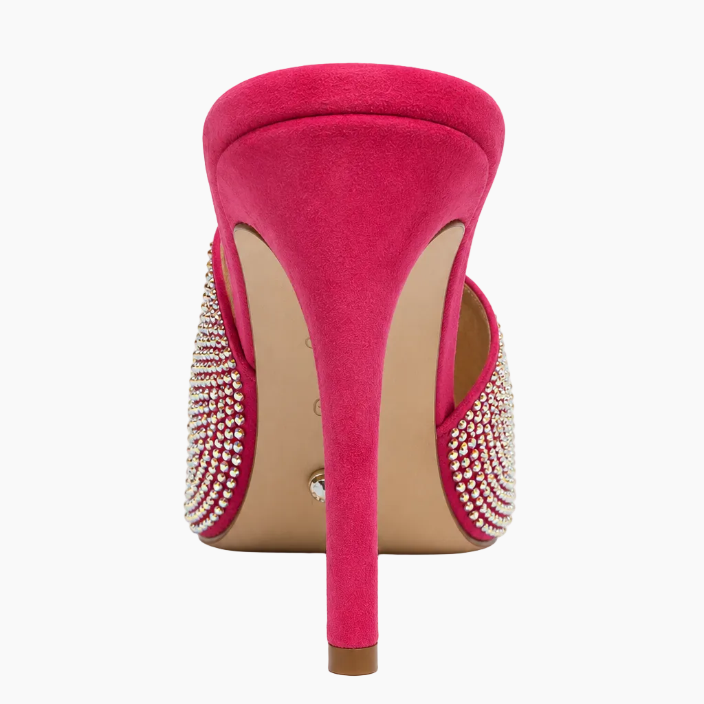 A single bright pink suede stiletto heel shoe shown from the back, featuring crystal-embellished side straps and a beige insole, set against a plain white background.