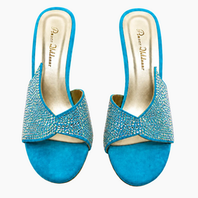 A pair of turquoise blue open-toe slingback mule sandals embellished with sparkling rhinestones across the straps, shown from a top-down view on a white background. The brand name 'Perez Aldamar' is visible on the insoles.