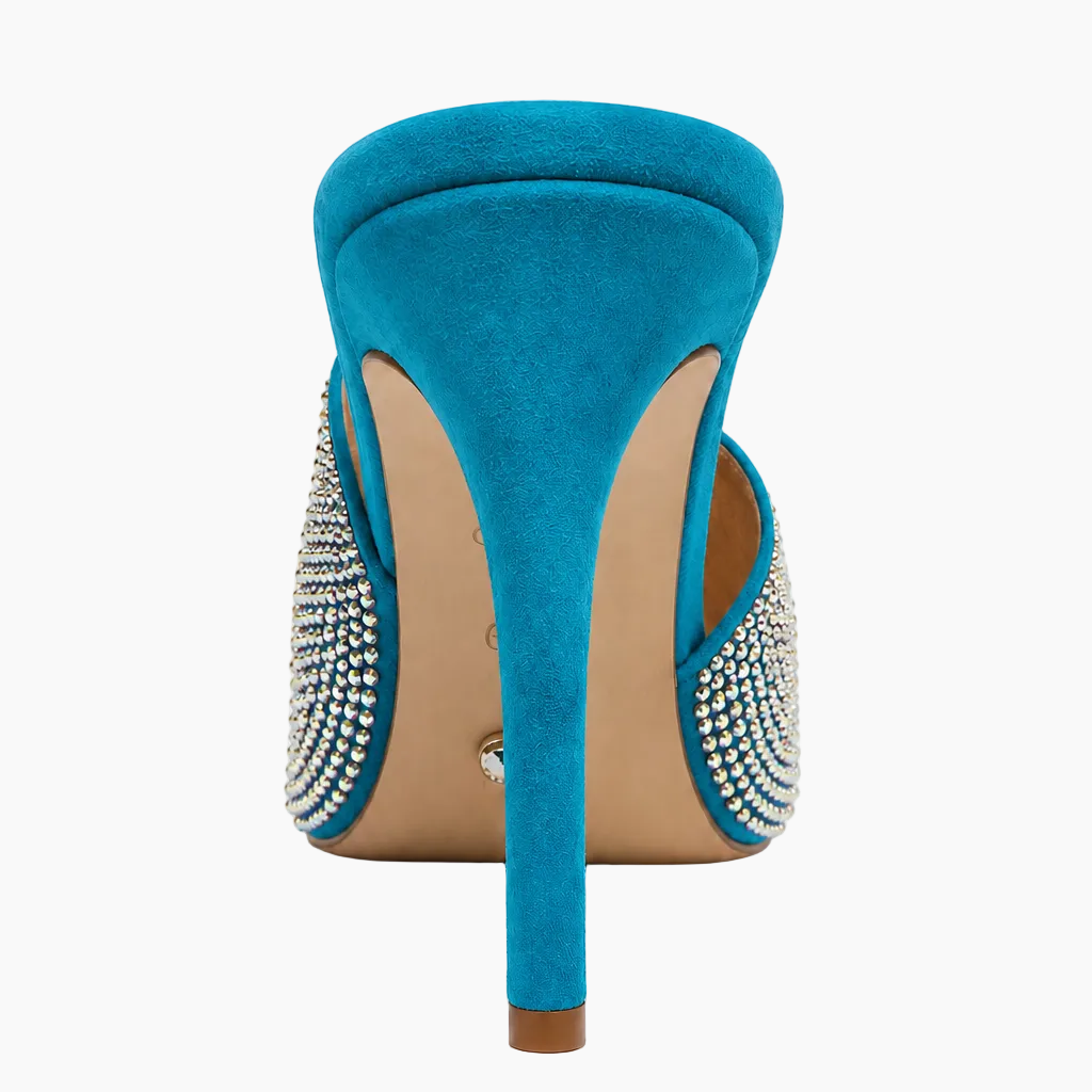 A single turquoise blue suede stiletto pump shown from the back, featuring silver rhinestone embellishments on the sides and a beige insole.