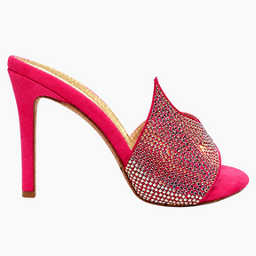 A single high-heeled mule sandal in bright pink suede, featuring a pointed toe embellished with dense multicolor rhinestones and a slim stiletto heel, shown against a plain white background.