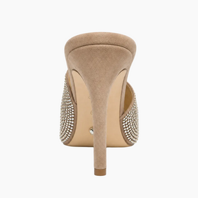 A single beige suede stiletto heel mule shoe shown from the back, featuring silver rhinestone embellishments on the sides, set against a plain white background.