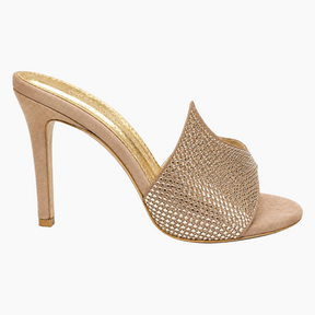 A single high-heeled mule sandal in a nude beige suede-like material, featuring a wide front strap covered in shimmering rhinestones, shown from a side profile on a white background.