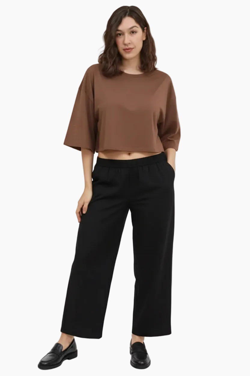 Woman wearing a beige oversized top and patterned pants 