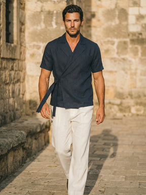 Man wearing a navy shirt and white pants 