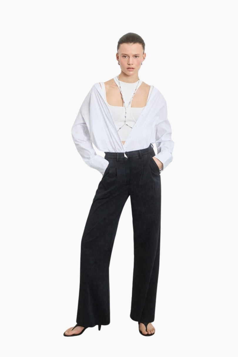 Person wearing a white blouse with cut-out design and black pants