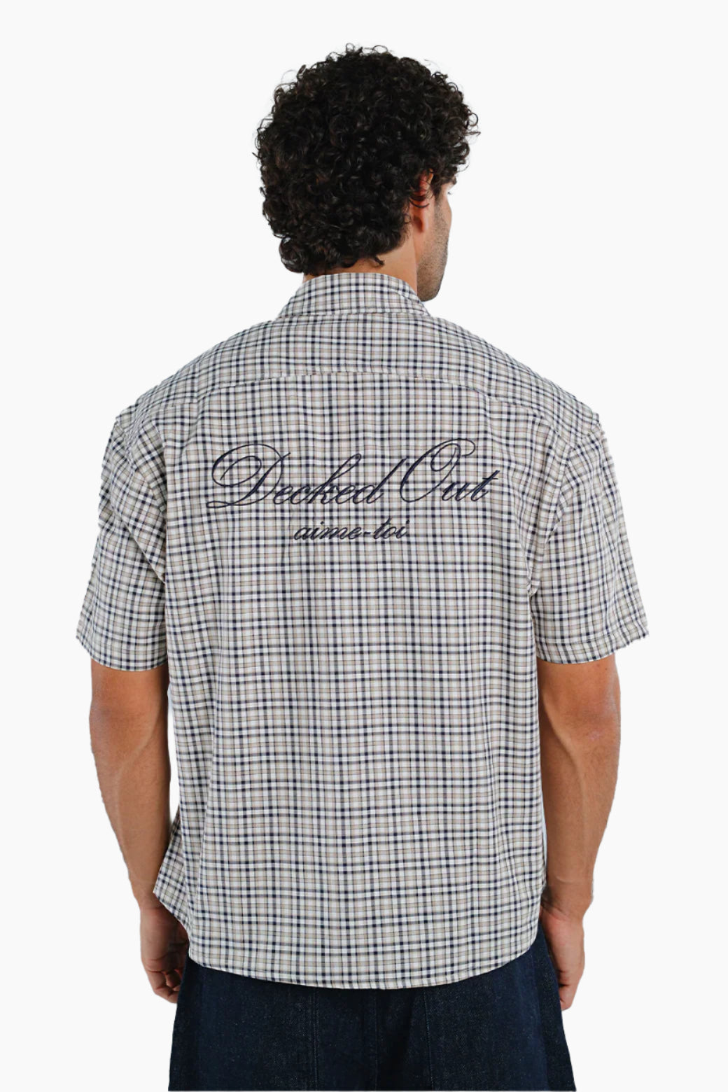 Man wearing a checkered shirt with text on the back 
