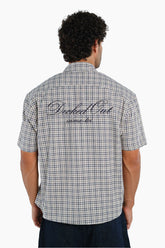 Man wearing a checkered shirt with text on the back 