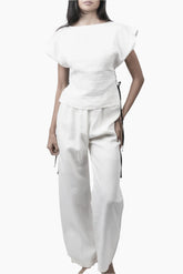 Relaxed yet redefined, these wide-leg pants are crafted from air pure Linen for effortless movement. Featuring an elastic waist for a comfortable fit, discreet side pockets, and a soft inner short lining for added coverage, perfectly paired with a Sleeveless lace up to for an adjusted waist and polished look.