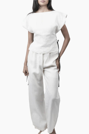 Relaxed yet redefined, these wide-leg pants are crafted from air pure Linen for effortless movement. Featuring an elastic waist for a comfortable fit, discreet side pockets, and a soft inner short lining for added coverage, perfectly paired with a Sleeveless lace up to for an adjusted waist and polished look.