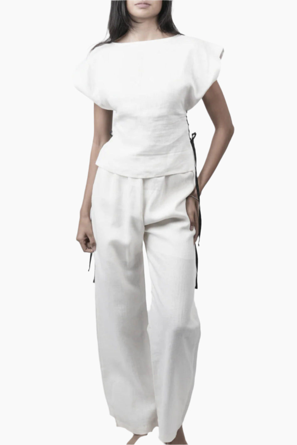 Relaxed yet redefined, these wide-leg pants are crafted from air pure Linen for effortless movement. Featuring an elastic waist for a comfortable fit, discreet side pockets, and a soft inner short lining for added coverage, perfectly paired with a Sleeveless lace up to for an adjusted waist and polished look.