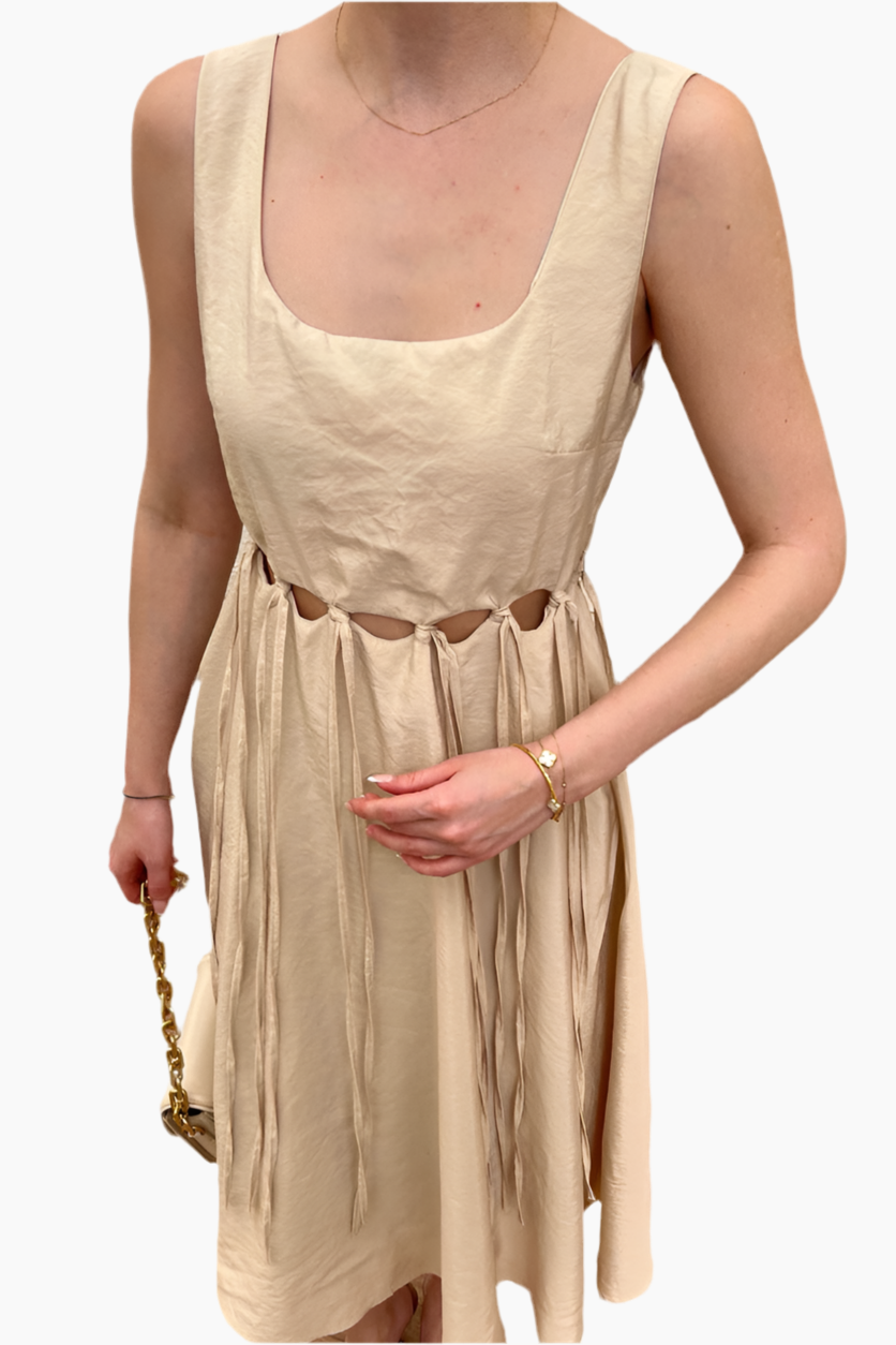 Beige sleeveless dress worn by a person on a white background