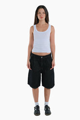 Person wearing a white tank top and black shorts