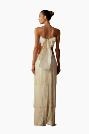 Woman wearing a beige strapless gown with a large bow detail