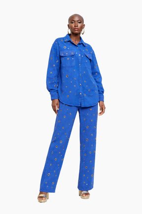 Woman wearing a blue outfit with gold patterns on a white background