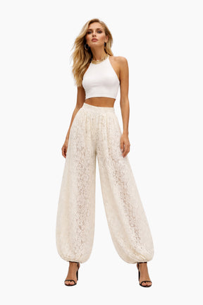 Woman wearing a white lace pants and top set on a white background