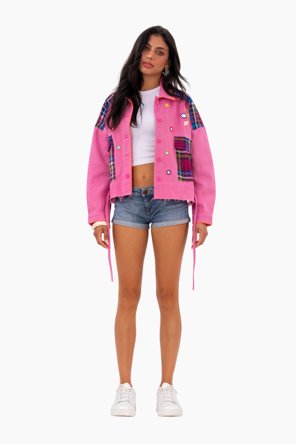 Woman wearing a pink plaid jacket on a white background
