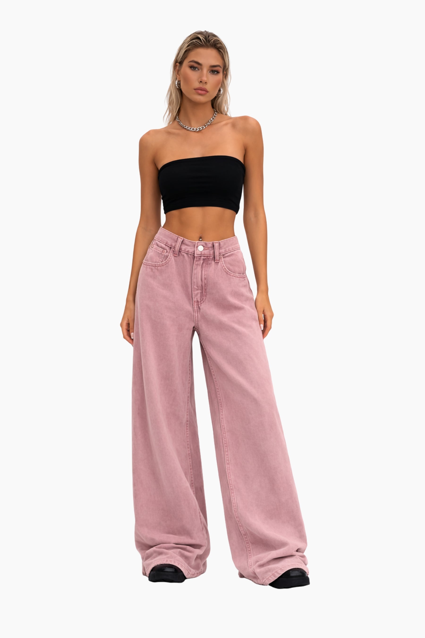 Woman wearing a black strapless top and pink wide-leg jeans on a white background