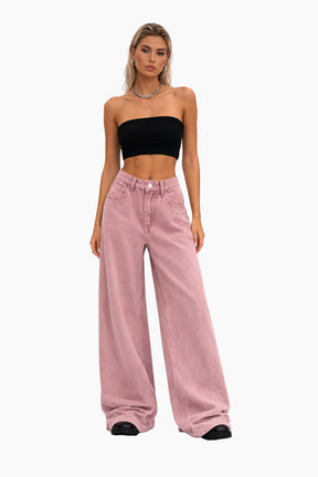Woman wearing a black strapless top and pink wide-leg jeans on a white background