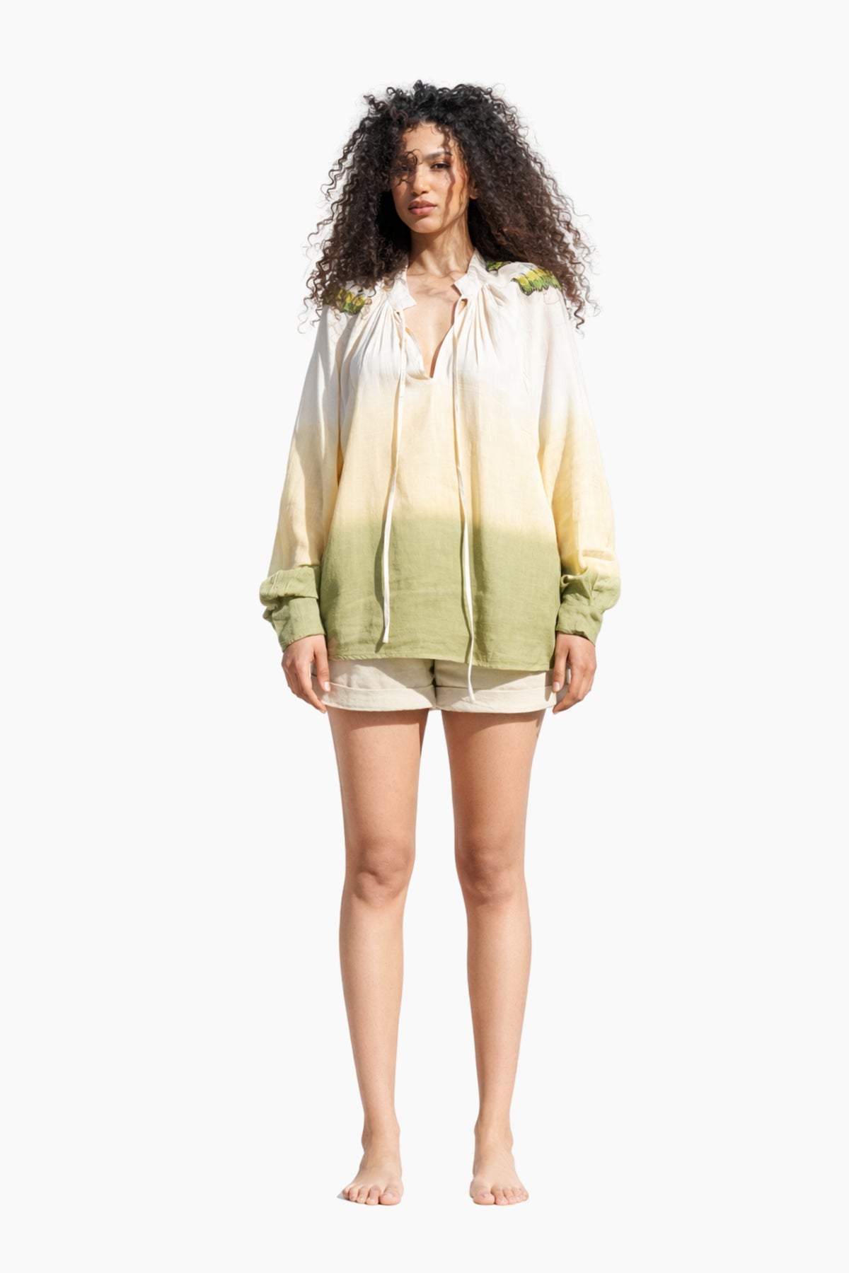 Woman wearing a gradient shirt and shorts on a white background