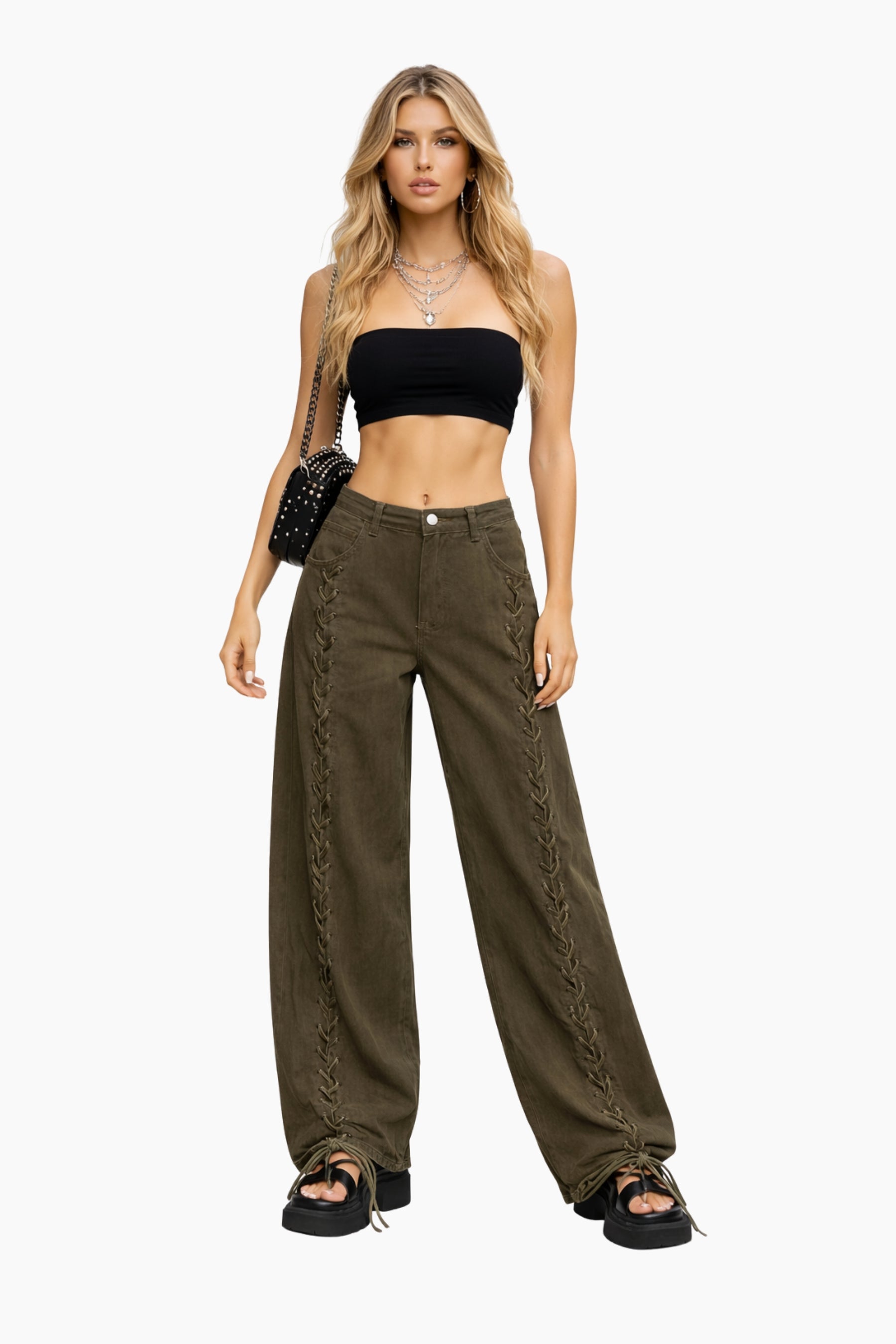 Woman wearing a black crop top and olive green pants on a white background