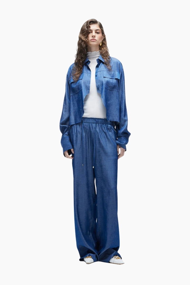 Person wearing a blue denim outfit on a white background