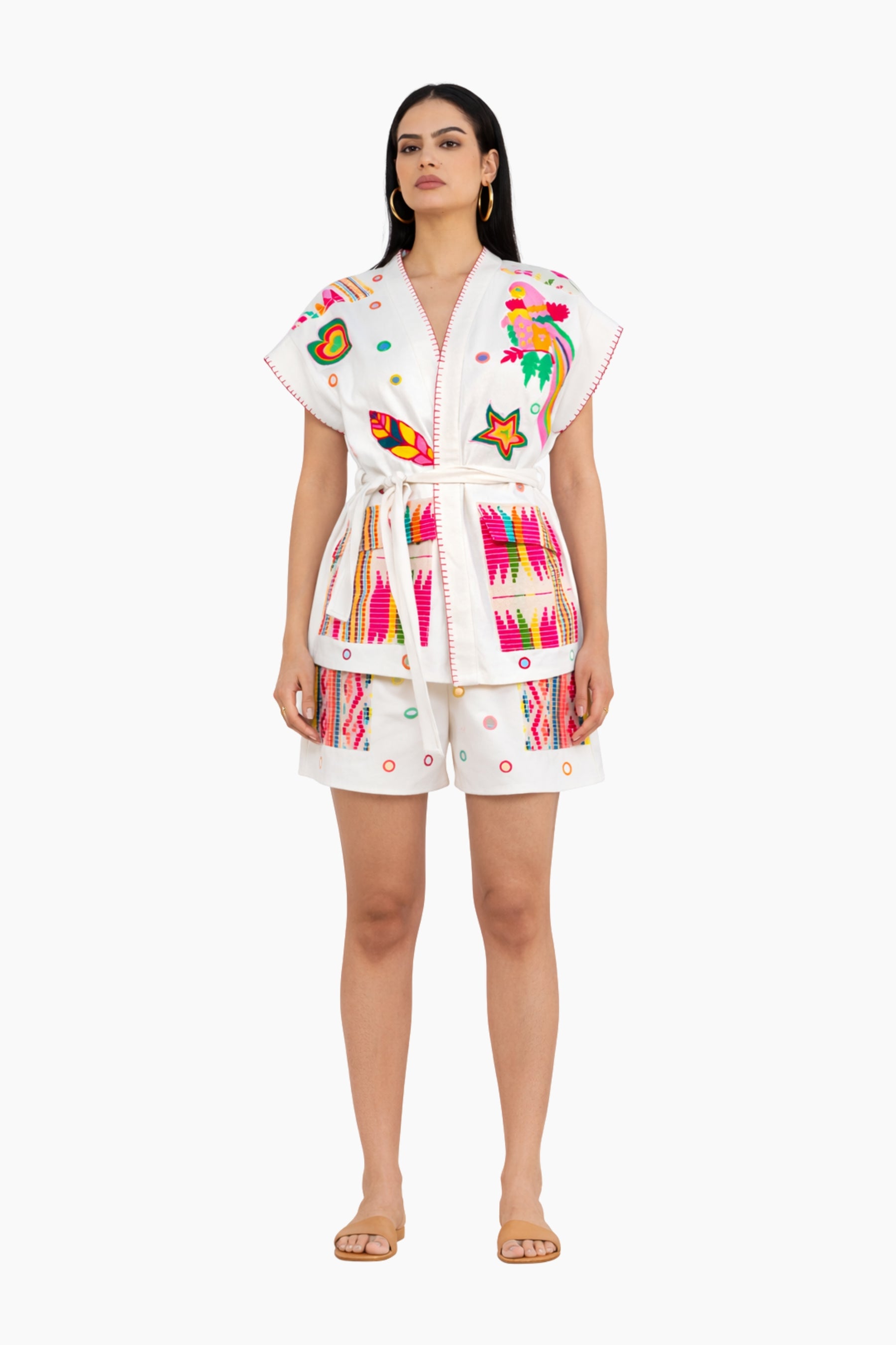 Woman wearing a colorful embroidered outfit on a white background