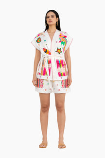 Woman wearing a colorful embroidered outfit on a white background