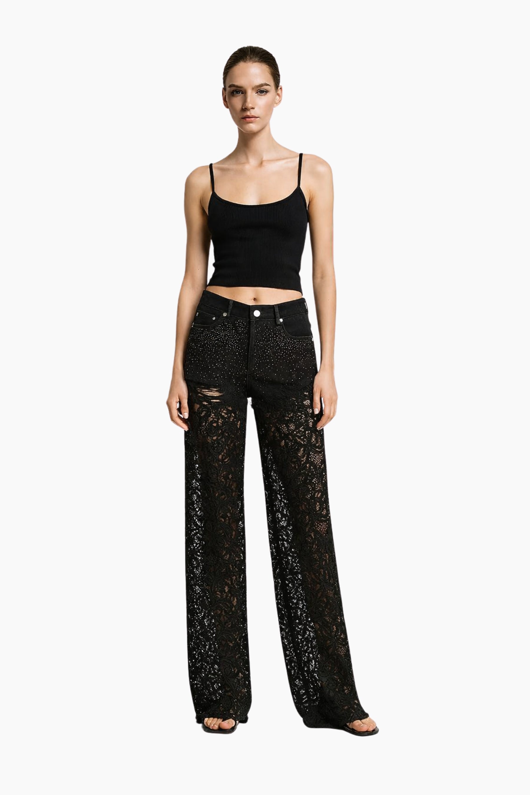 Model wearing black lace top and pants on a white background