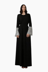 Black dress with silver cuffs on a white background