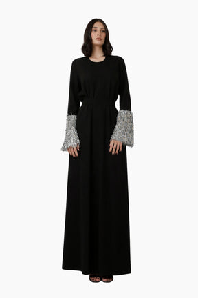 Black dress with silver cuffs on a white background