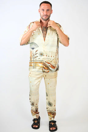 Man wearing a stylish outfit with floral and musical note patterns on a white background