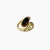 Gold ring with a dark gemstone on a white background