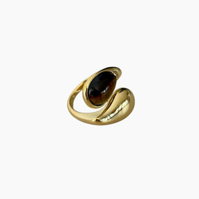 Gold ring with a dark gemstone on a white background